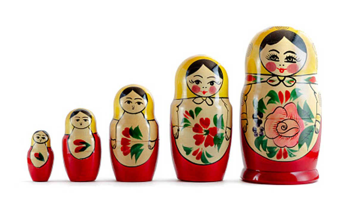 Uma foto de um conjunto de bonecas russas alinhadas uma ao lado da outra.